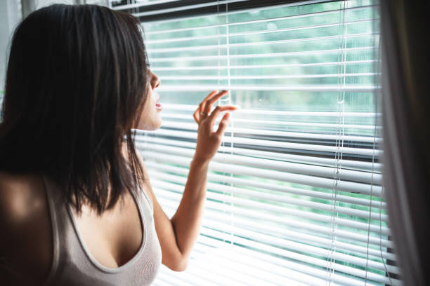 istock pensive chinese girl watching outside the window 2185923963