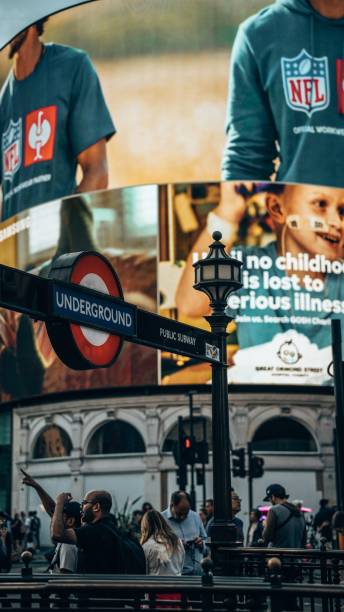 Piccadilly Circus in London,with Underground sign and large digital advertisements on the background London, United Kingdom – September 20, 2024: A vertical shot of Piccadilly Circus in London, with the iconic Underground sign and large digital advertisements on the background digital underground stock pictures, royalty-free photos & images