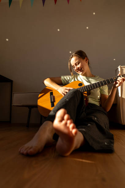 istock A woman playing a guitar 2185927131