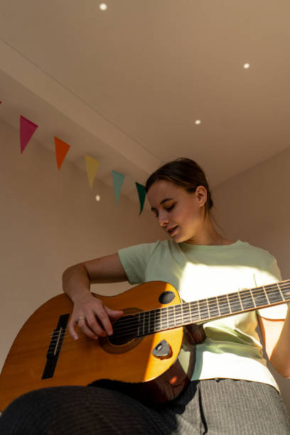 istock A woman playing a guitar 2185927133