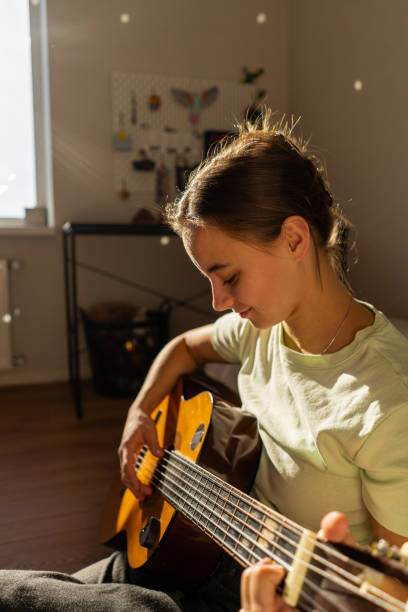 istock A woman playing a guitar 2185927344