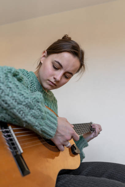 istock A woman playing a guitar 2185927377