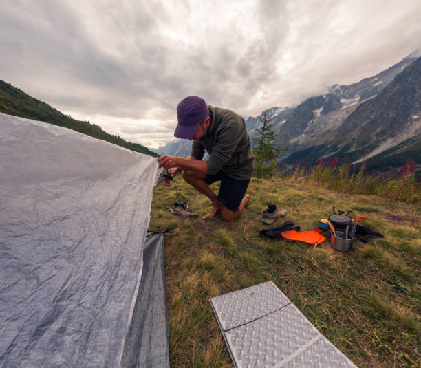 istock Camper Pitching Tent in Mountain Wilderness 2185929014