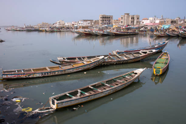 Saint Louis, Senegal - May 29, 2014: Fishing canoes, surrounded by garbage, in the waters of the river Senegal, which crosses the city