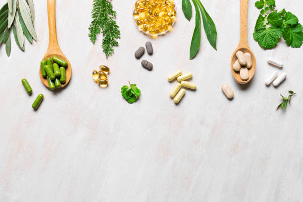 istock Plant based vitamin capsules and green leaves 2185930684