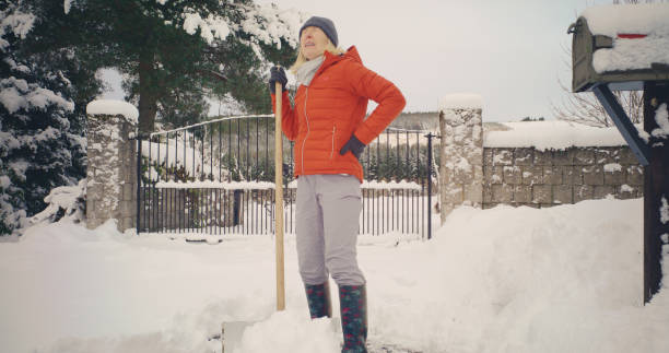 istock Senior woman backache shovelling snow 2185933252