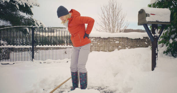 istock Senior woman backache shovelling snow 2185933297