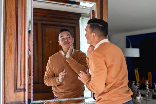 istock Man looking at himself in front of a mirror at home. 2185933919