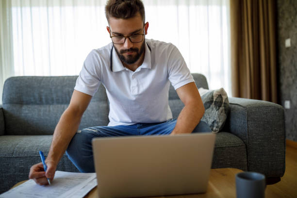 istock Young man focusing on his laptop and notes, actively learning or following an online tutorial 2185949100