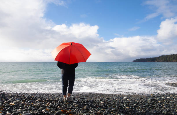 istock Woman with red umbrella, sea 2185949595
