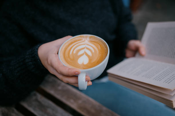 istock A woman reads a book while enjoying a coffee 2185952037