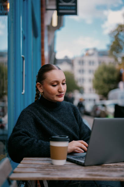 istock Young woman using her laptop at a cafe 2185952106
