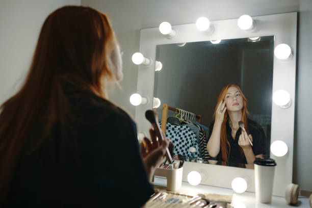 istock Applying Makeup in Dressing Room with Mirror Lights 2185952433