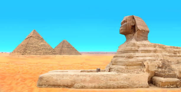 istock Famous Great Sphinx and pyramids of Chephren and Cheops, Cairo, Egypt. Great Pyramids, ancient statue of Sphinx and beautiful sand dunes, Giza complex (Giza Necropolis) 2185954213