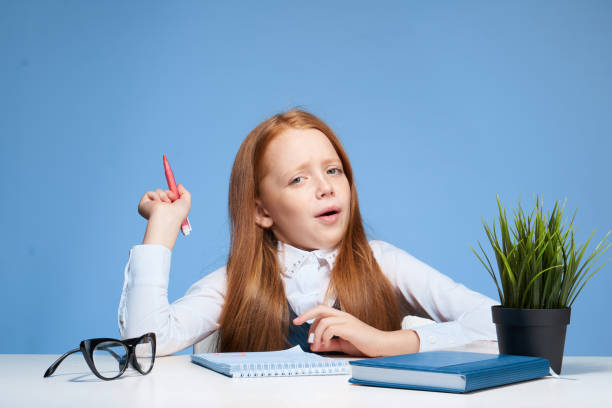schoolgirl doing homework at the table education lifestyle. High quality photo
