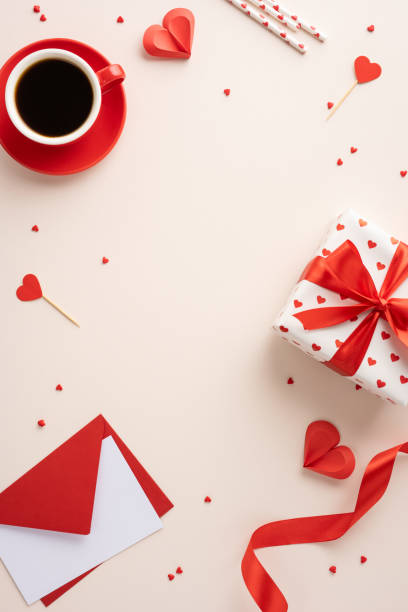 Valentine's Day vertical themed image featuring a coffee cup, wrapped gift, hearts, and envelope on a beige background creating a romantic atmosphere