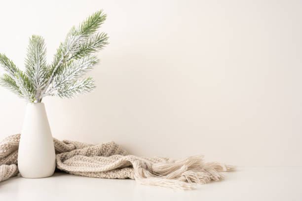 istock A side view simple and elegant winter scene featuring frosted pine branches in a vase with a cozy knit scarf. The Scandinavian style creates a serene and calming atmosphere 2185957289