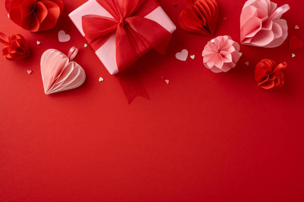 istock A beautifully wrapped gift box on a red background, surrounded by paper hearts and decorations, creating a romantic Valentine's Day atmosphere 2185957329