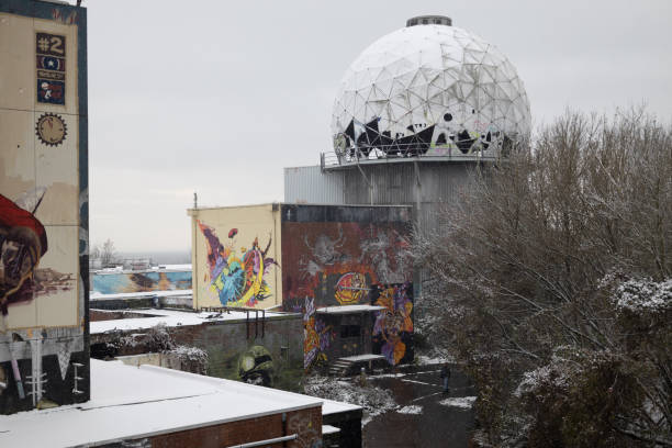 Berlin, Germany – November 11, 2022: An aerial view of a large satellite perched atop a snow-covered building amidst a wintery landscape
