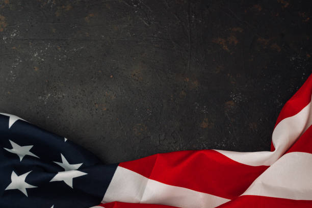 istock Red and white American flag is displayed on a black background 2185961941