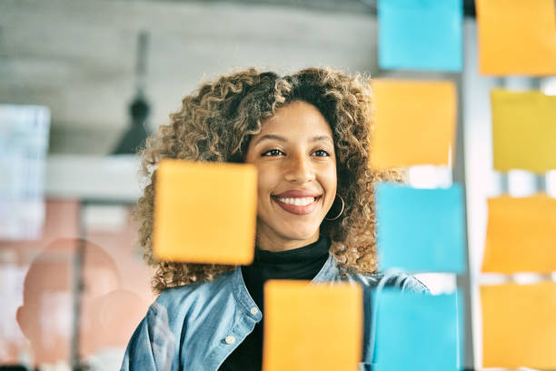 istock Smiling businesswoman brainstorming ideas with sticky notes in office 2185972364