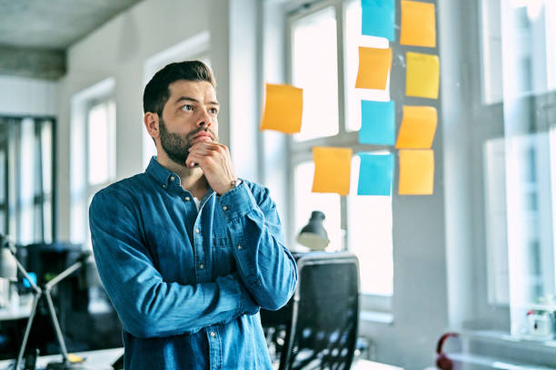 Businessman brainstorming new project ideas with sticky notes in office