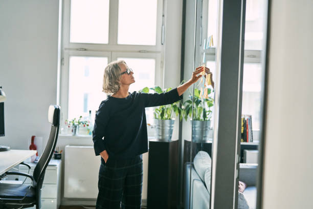 istock Senior businesswoman analyzing sticky notes for new project in office 2185972436