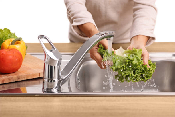 istock Female hands washing a lettuce salad in a sink 2185976801
