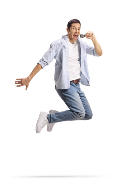 istock Happy young man jumping and singing on a microphone 2185976812