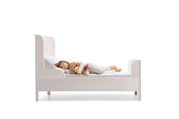 istock Kid with a teddy bear sleeping in a bed 2185977661