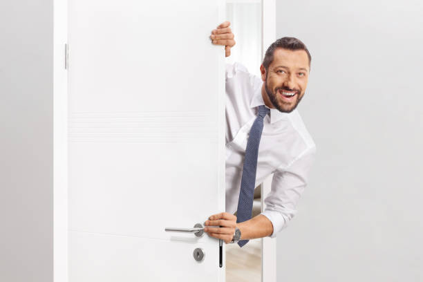 istock Cheerful businessman standing behind a door 2185978912