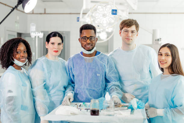 Female doctor and nurse looking at each other while doing artificial fertilization for cropped woman patient in reproductive clinic. Embryology and biotechnology