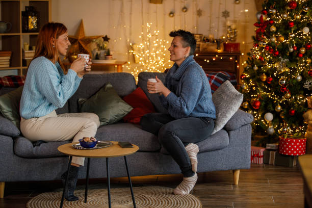 istock Friends enjoying coffee and conversation by the Christmas tree 2185992324