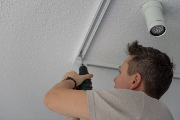 istock A person is attaching a light fixture to the ceiling using a drill. 2185993369