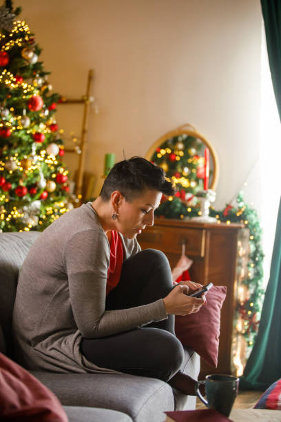 istock Relaxed woman using mobile phone at Christmas 2185993685