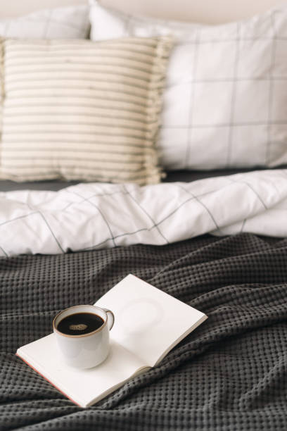 istock Cozy morning routine with coffee and a book on a comfortable bed 2185993755
