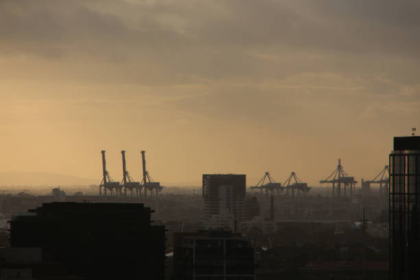 Tower cranes at Port Melbourne with dramatic sky above  ￼