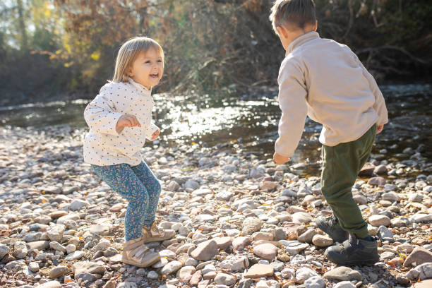 istock Brother and sister having fun by the river 2186011050