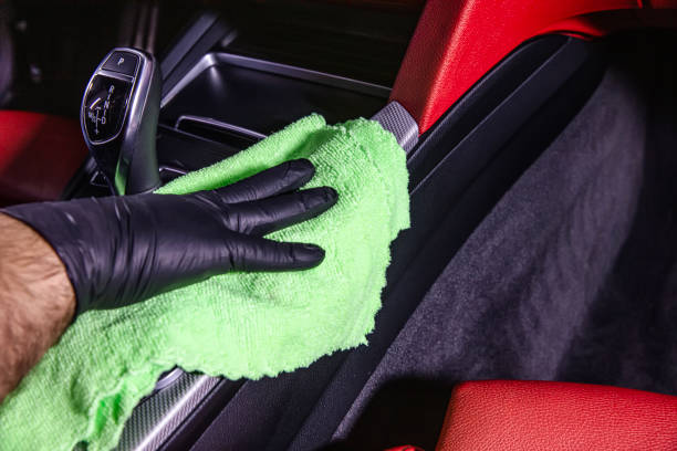 istock Hand cleaning the car interior with green microfiber cloth. Hand with microfiber cloth cleaning leather seat,auto detailing and valeting concept,washing car care interior. 2186018460