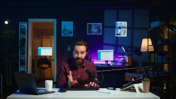 istock Man filming video for online channel, presenting mouse and keyboard 2186018735