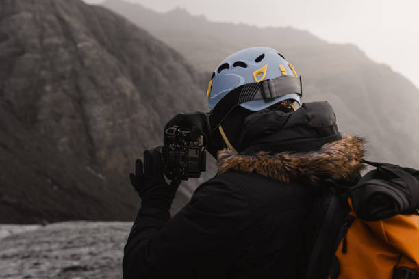Videographer wearing helmet recording in mountain environment