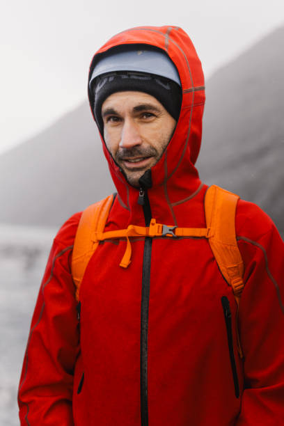 istock Mountaineer wearing red jacket and backpack smiling at camera 2186021795