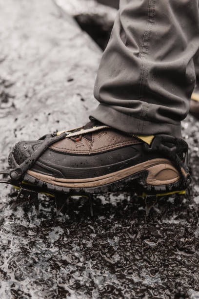 Hiker walking on glacier wearing crampons for safety