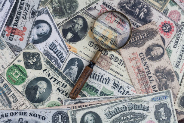 istock Old US banknotes and silver certificates with silver dollar coins and magnifying glass 2186032855