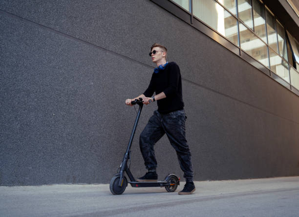 istock Young man, full body shot standing and posing on electric scooter 2186037205