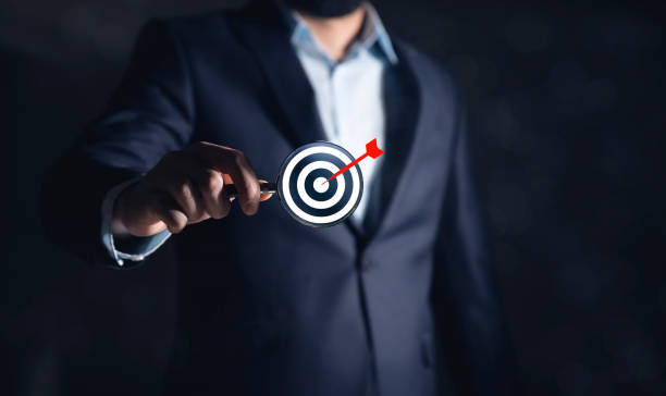 istock holding magnifying glass with white dartboard 2186039589