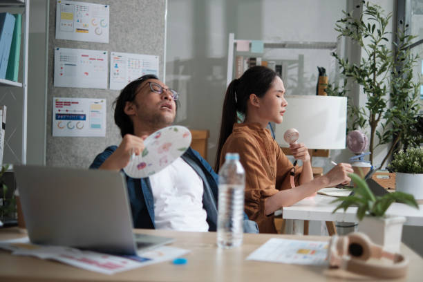 istock Two Asian workers are unhappy working with hot temperatures at office in summer. 2186040598