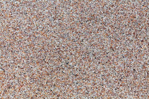 Close-up of a weathered house exterior, finished in pebbledash or roughcast, with small stones embedded into the finish.