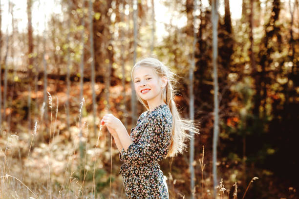 A beautiful, eight-year-old girl enjoying nature in the fall. Shot with a Canon 5D Mark IV.
