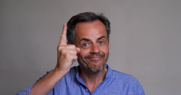 istock smiling pointing warning you mature man on gray background 2186049290